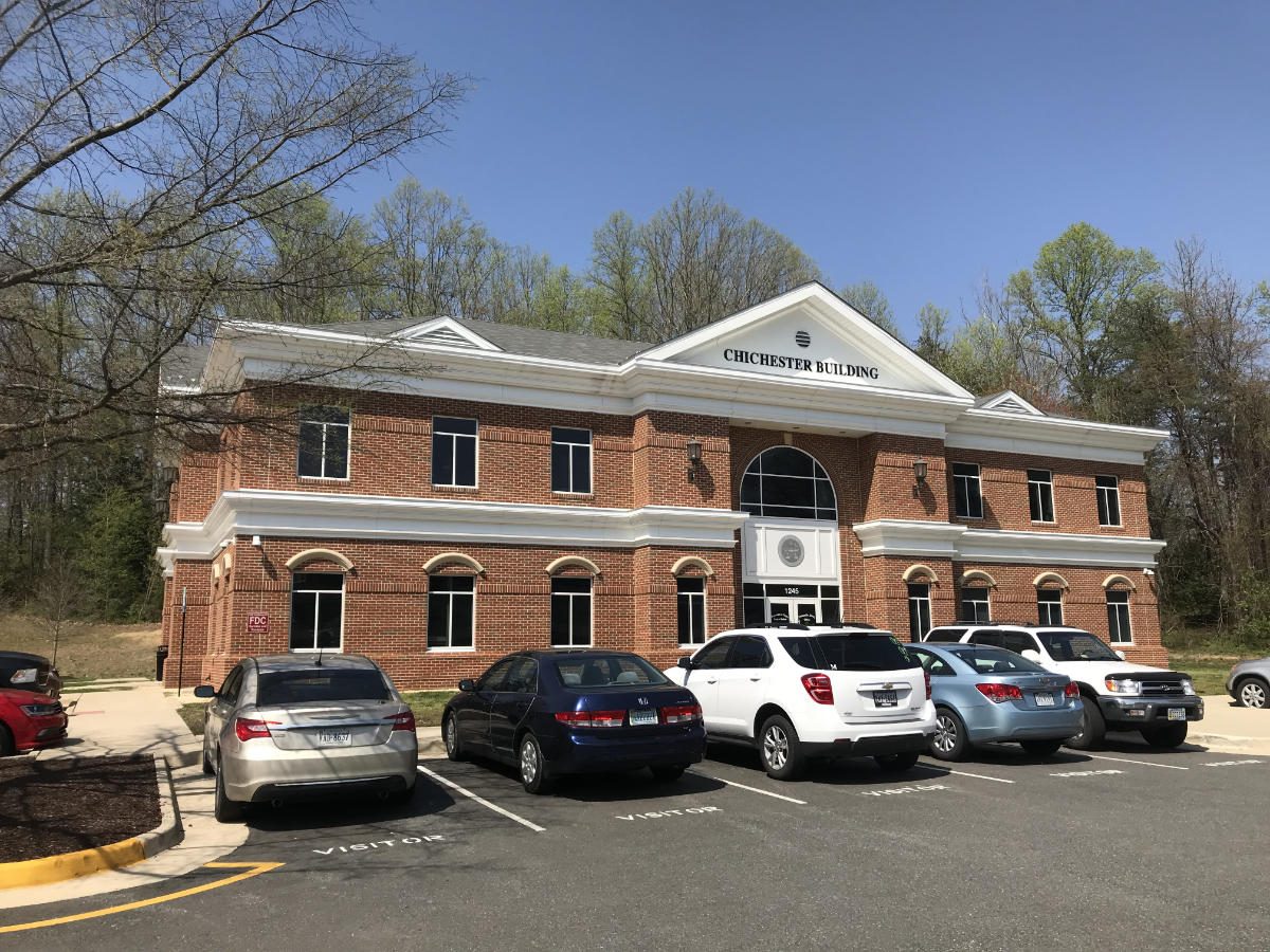Two story brick Chichester Building with white pediment entry in Stafford County, Virginia